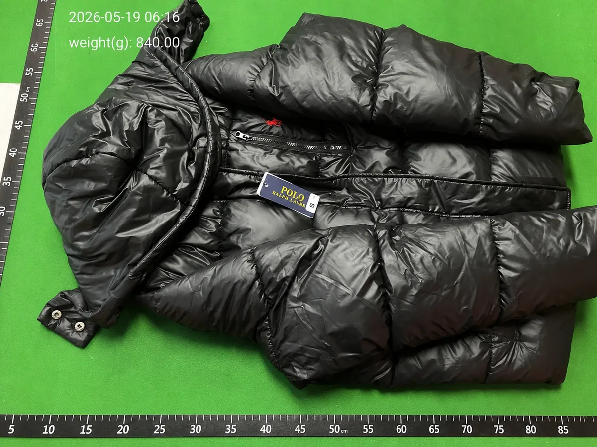 QC inspection photo of a black puffer jacket beside measurement scales with weight details